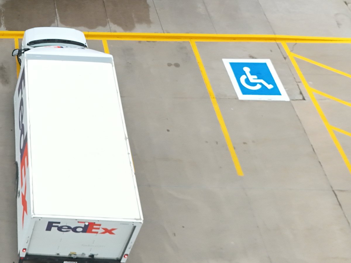 Drone view of freshly painted parking lot stripes and accessible parking symbol after striping